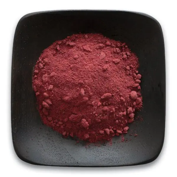 A black bowl filled with red powder on top of a table.