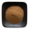 A bowl of brown powder on top of a table.