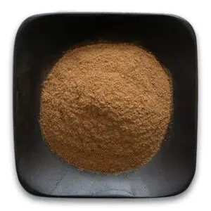 A bowl of brown powder on top of a table.