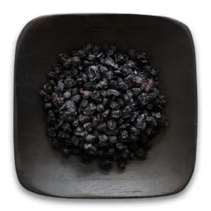 A bowl of black beans on top of a table.